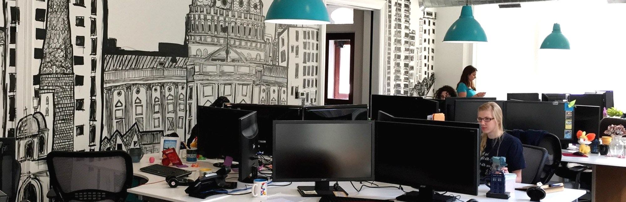 a woman sits at a desk in front of an acer monitor