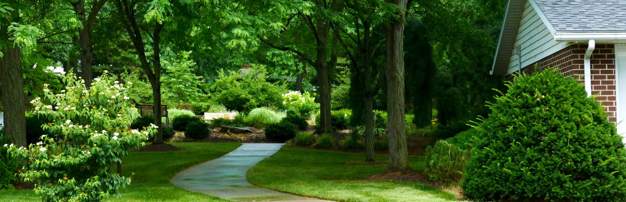 a brick house in a retirement community is surrounded by trees and bushes