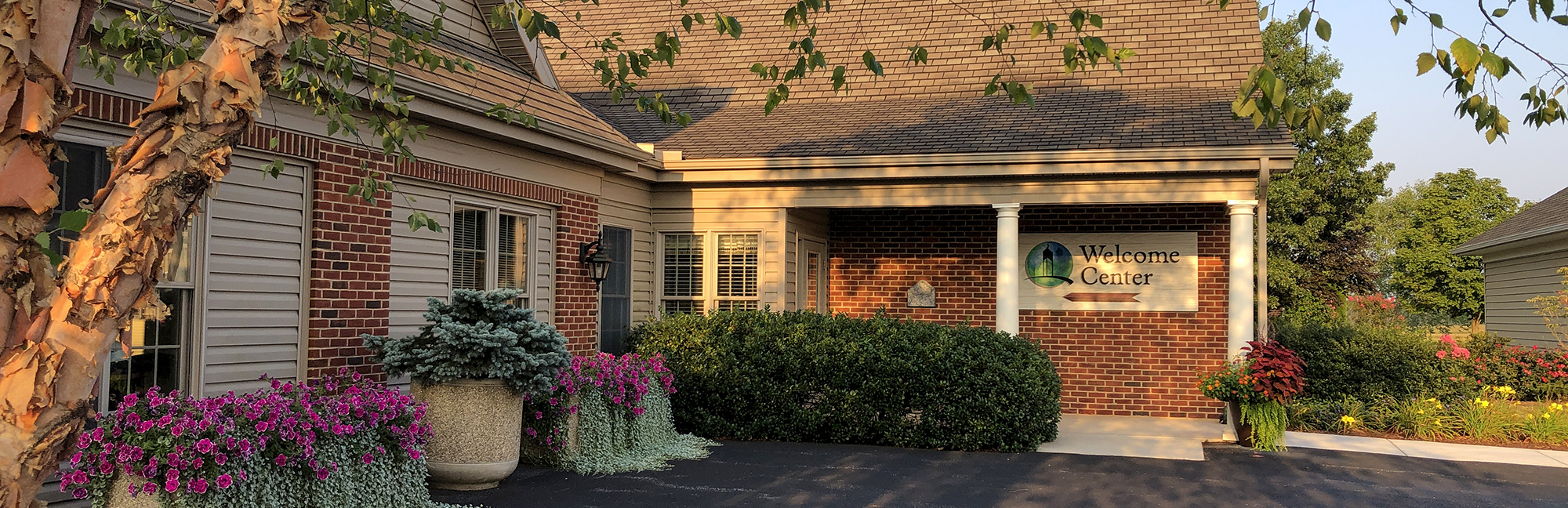 Outside of a brick building with a sign on the side that says welcome center