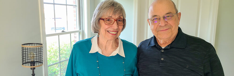 man and woman smiling in a home by the window