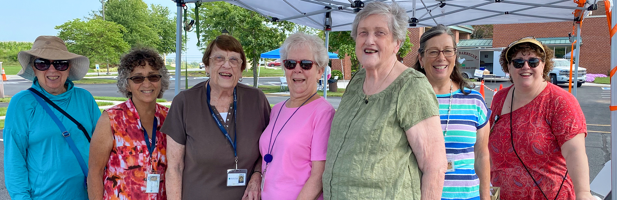 a group of older women are posing for a photo under a tent