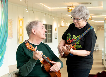 Two elderly people playing ukulele's together