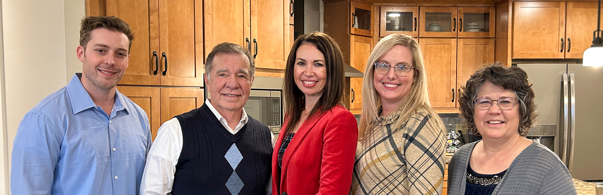 a happy family posing for a picture in the kitchen of a retirement home