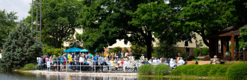 Residents of Cross Keys Village sitting by a body of water watching someone